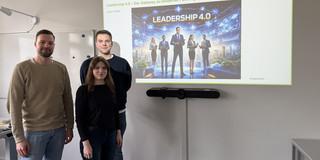 Von links nach rechts: David Brinkhaus, Laura Wuttke und Simon Telgheder stehen neben der Titelfolie "Leadership 4.0" .