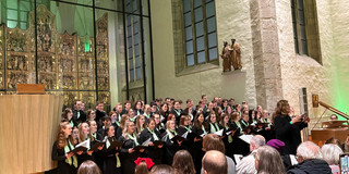 Der Unichor vor dem Altar in der Petri-Kirche. Rechts im Bild steht die Chorleiterin Heinke Kirzinger.